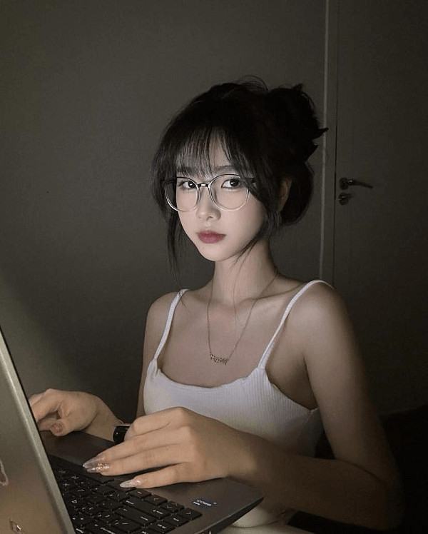 Nữ sinh tóc dài đeo kính, tạo dáng đáng yêu.