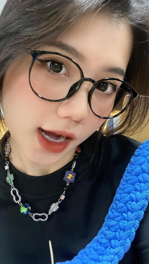 Gái xinh tóc ngắn đeo kính, nụ cười rạng rỡ.