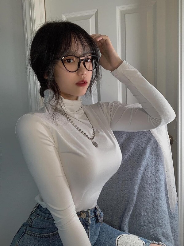 Cô gái tóc ngắn đeo kính, tạo dáng xinh xắn.