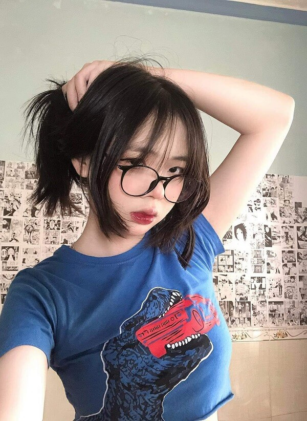 Gái xinh tóc ngắn đeo kính, nụ cười tươi tắn.